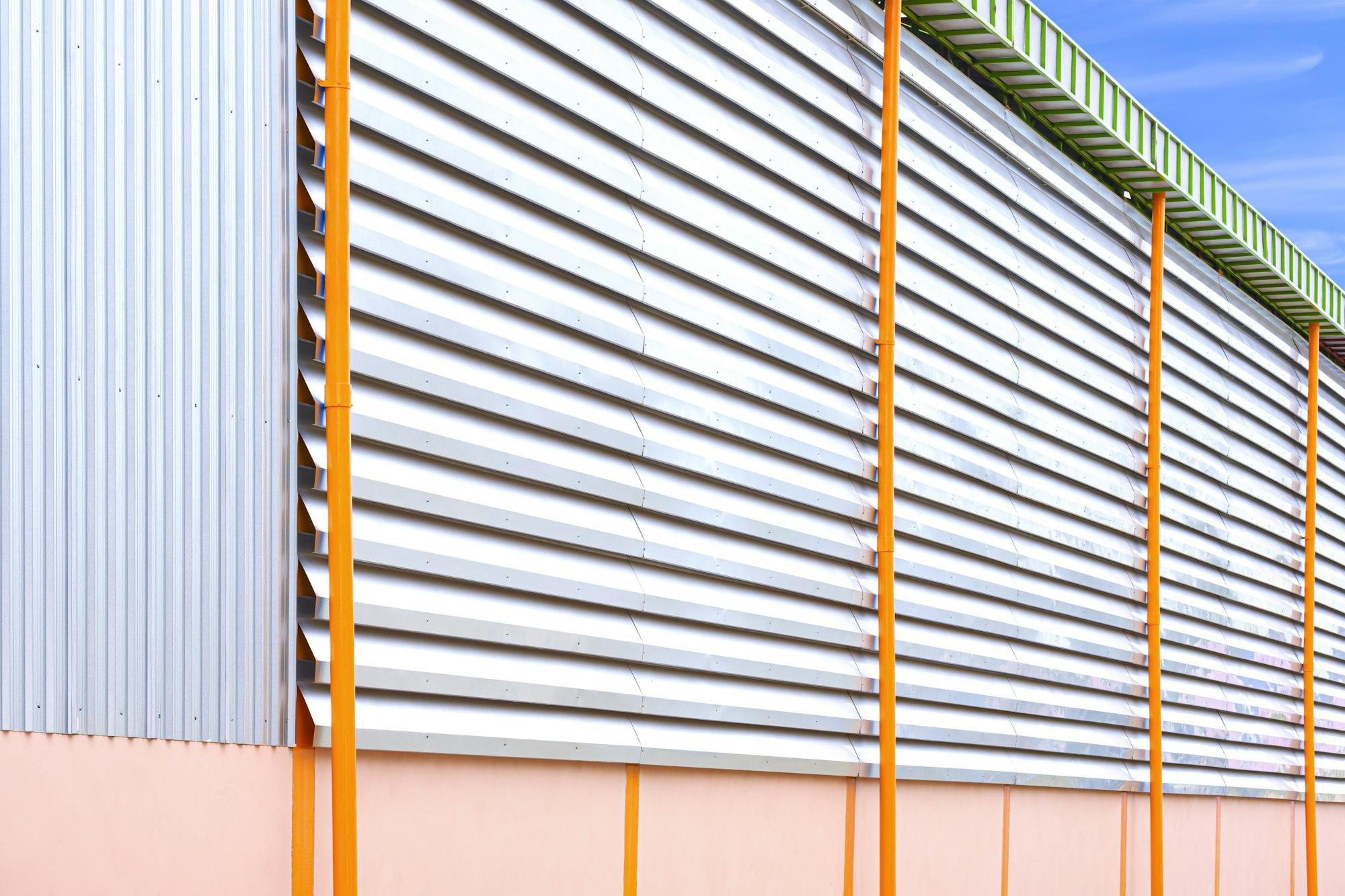 Side view of aluminum louver with gutter drainage system outside of industrial building