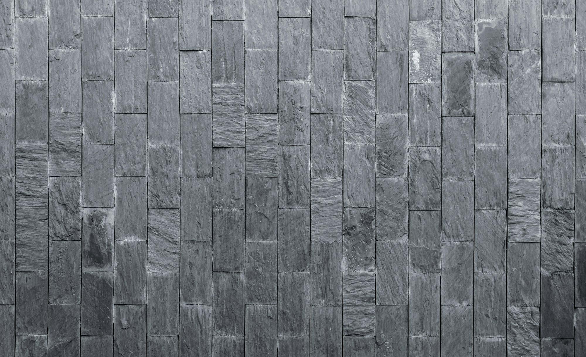 Stone cladding texture background. Gray stone wall. Stone brick for home exterior decor. Dark